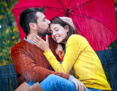 Dualseele erkennen Paar sitzt gemeinsam bei Regen unter einem Schirm